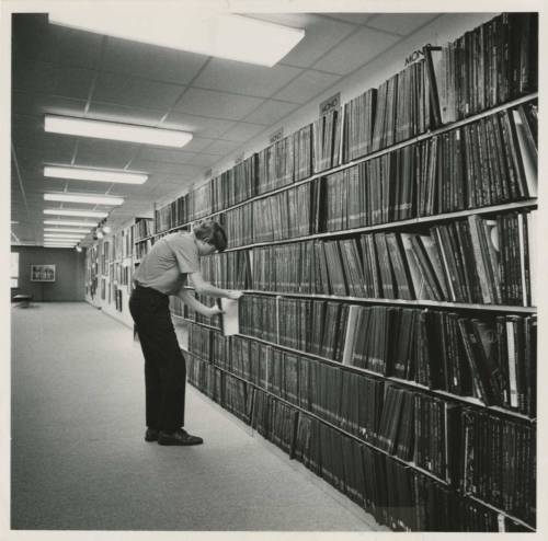 Man_looking_through_record_albums_in_the_Art_Department